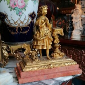 Escultura en bronce dorado sobre base de mármol rosa